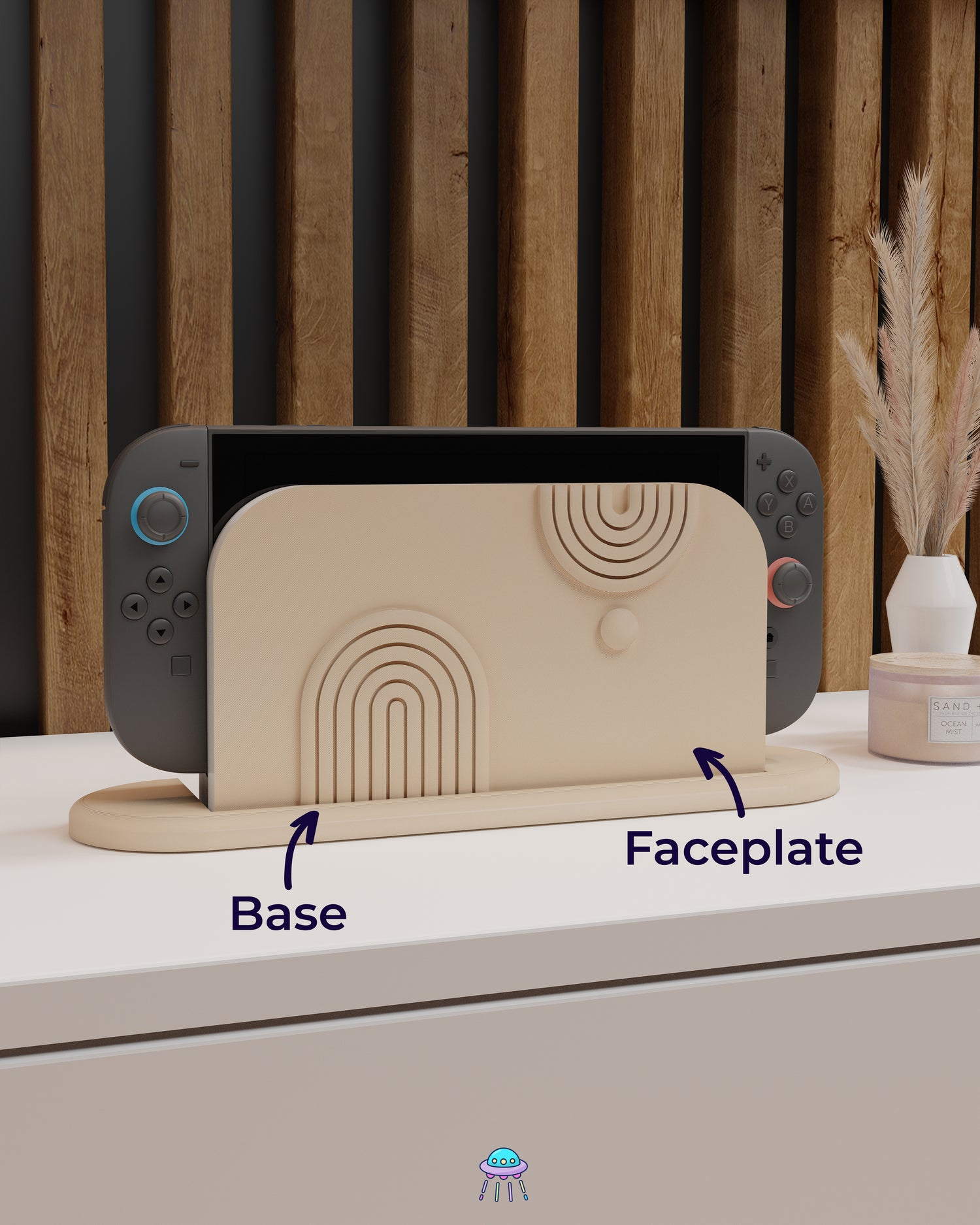 A Nintendo Switch 2 with Joy-Con controllers docked in a customised dock featuring a beige PLA filament cover and base. The cover has two embossed arch designs on the front—one larger arch at the bottom left and a smaller arch in the top right corner, alongside a small circular detail. The setup is placed on a white cabinet with a wooden panel background and decorative items nearby, including a candle and a vase with dried pampas grass. Arrows point to the dock cover and dock cover base.